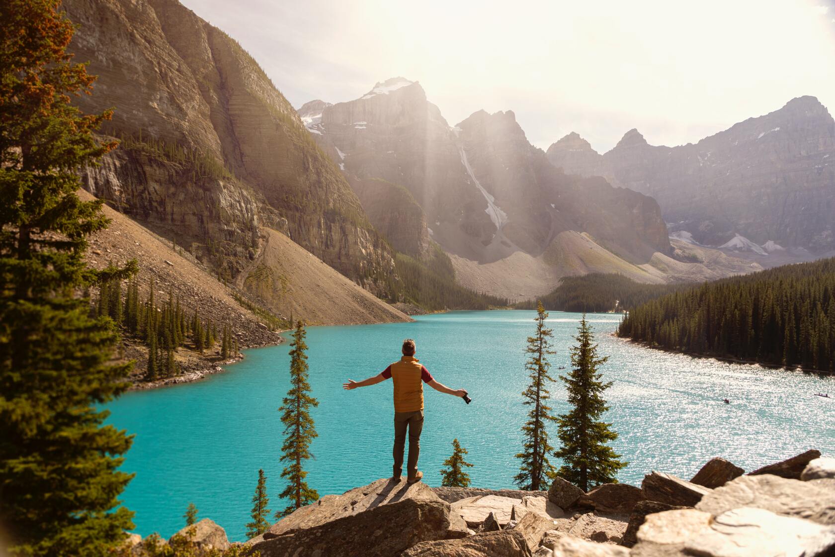 Traveler admiring turquoise Moraine Lake and mountains on Lake Louise tour from Calgary.