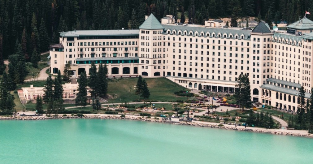 Fairmont Château Lake Louise overlooking turquoise waters and surrounded by forested mountains