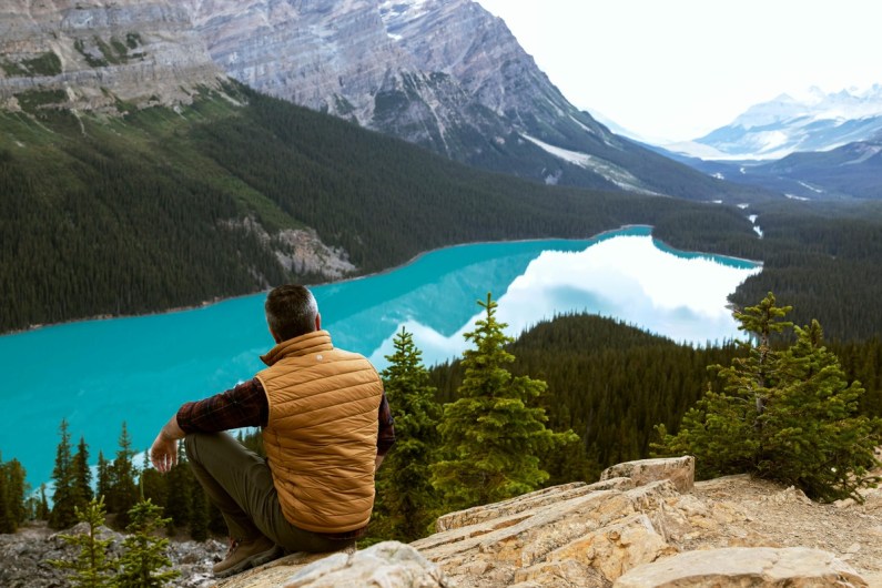 Traveler admiring turquoise Moraine Lake from mountain viewpoint in Banff National Park