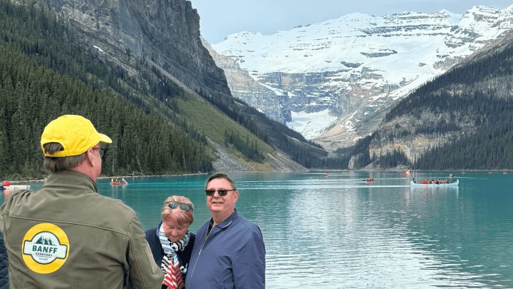 Tour guide with visitors at Lake Louise with glacier views during Banff glacier tour.