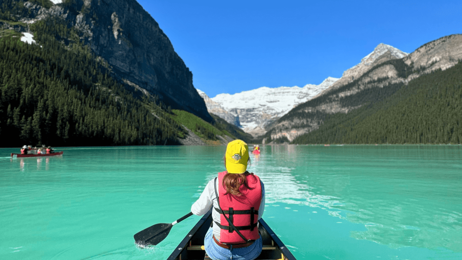 Traveler canoeing on turquoise Lake Louise with glacier view during Banff glacier tour.